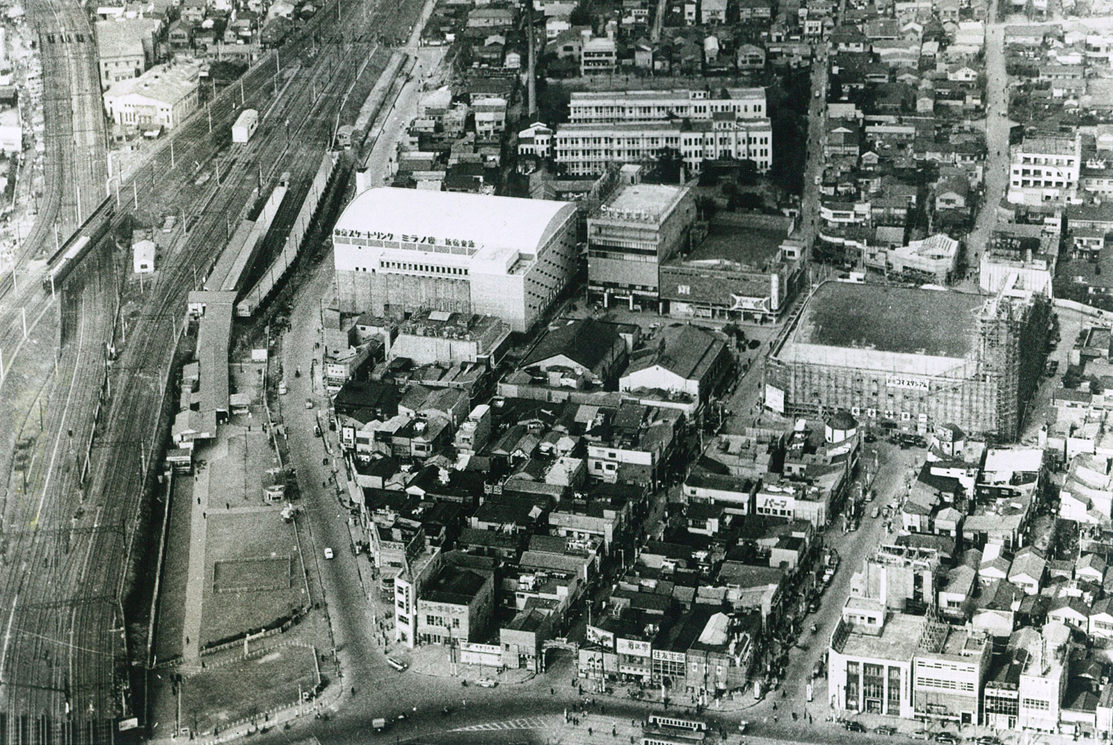 1956年当時の様子を捉えた航空写真。中央右手の建物に「コマ・スタジアム」（コマ劇場運営元）の文字が見える。